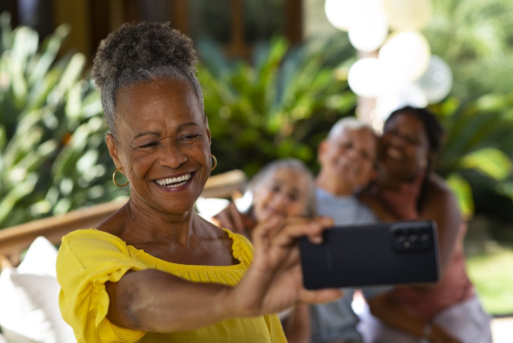 Older lady taking a selfie with her family