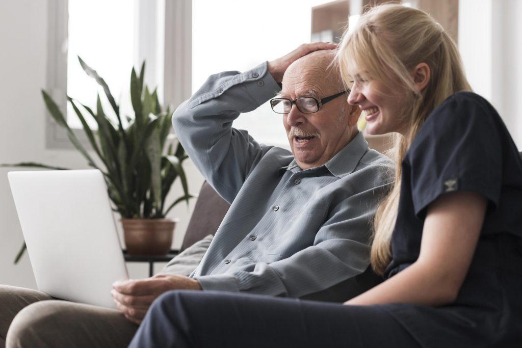 Old man on a video call with a nurse by his side