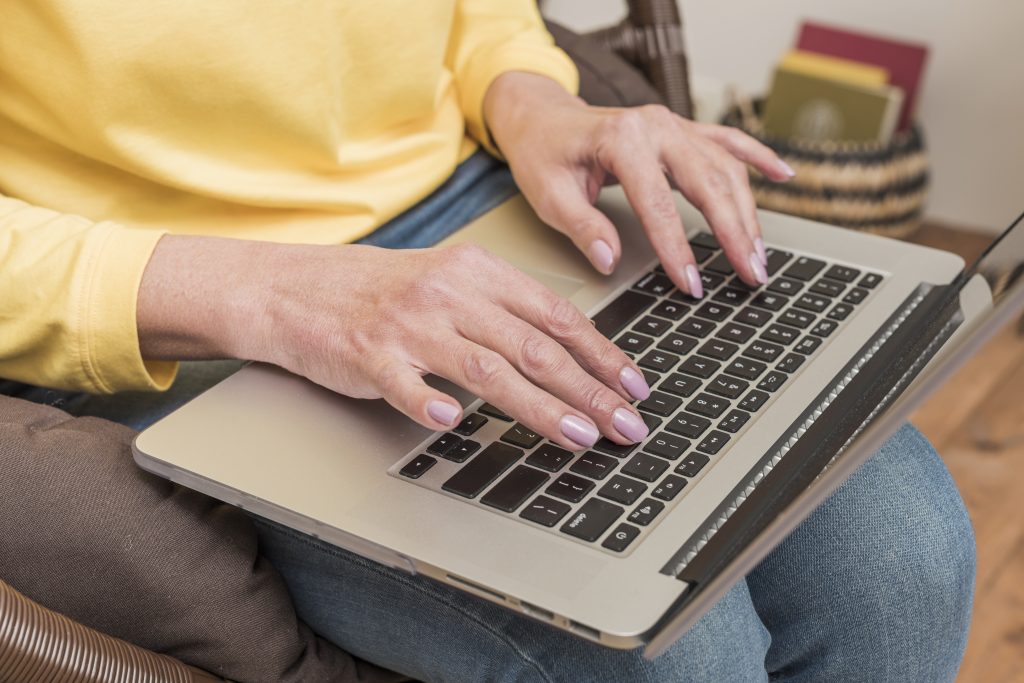 Person typing on a laptop on their lap